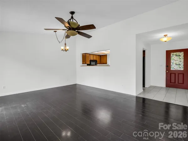 an empty room with windows and fan