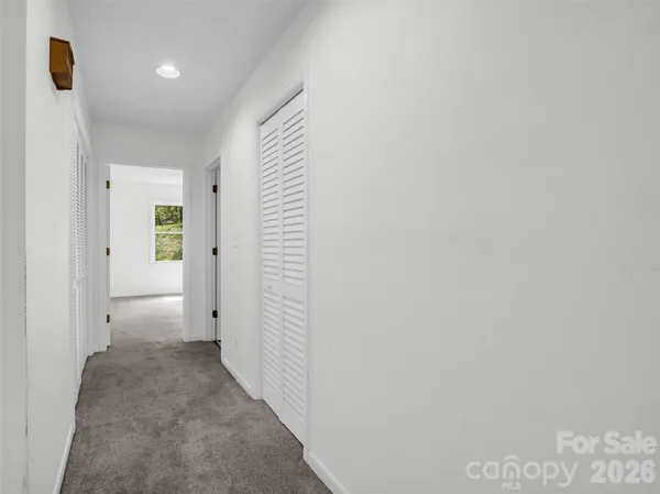 an empty room with windows and ceiling fan