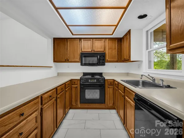 a hallway with a stove a microwave and a potted plant