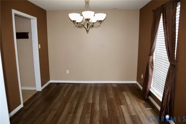 a view of a room with wooden floor fan and windows