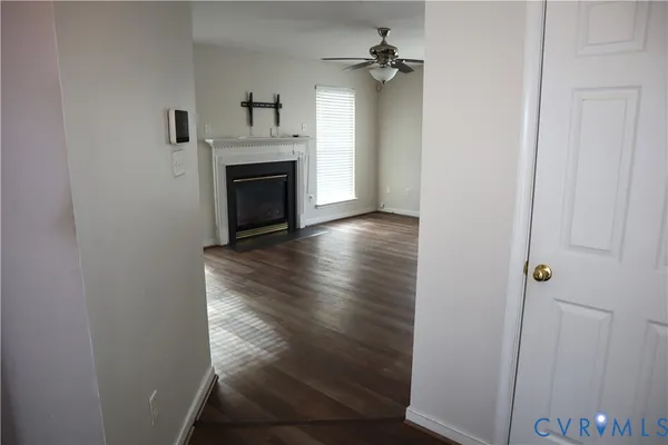 a view of a hallway with wooden floor and a chandelier