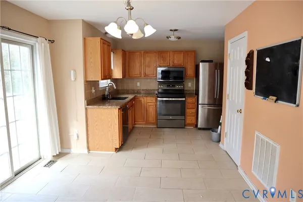 a kitchen with stainless steel appliances granite countertop a refrigerator a stove top oven a sink and dishwasher