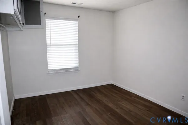 a view of a small space with wooden floor and a window