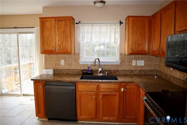 a kitchen with granite countertop a sink a stove and a microwave