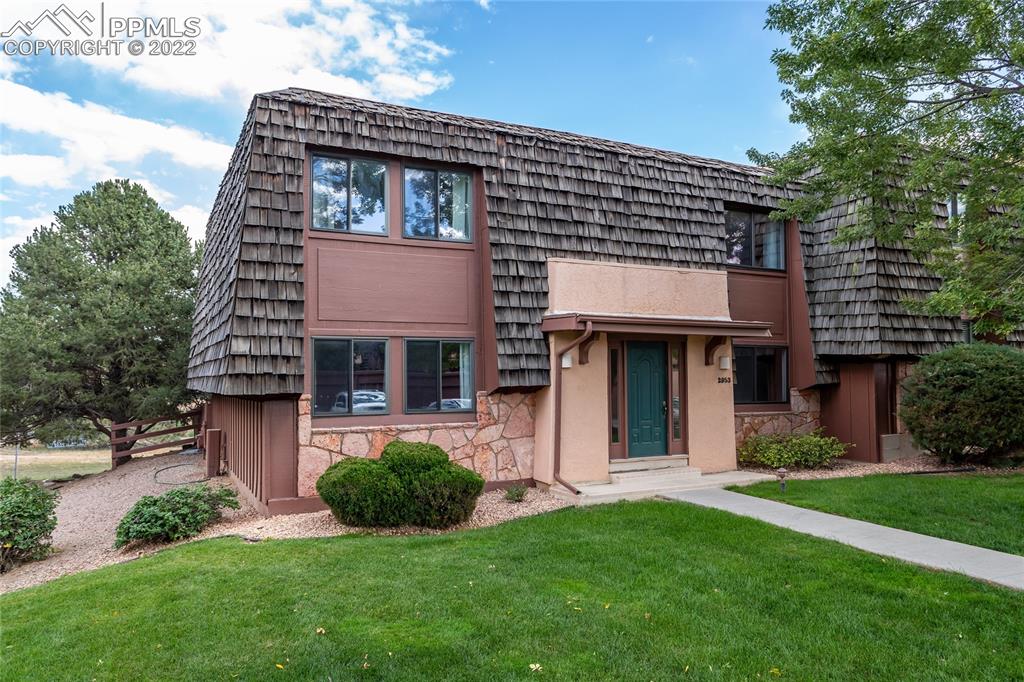 a front view of a house with a garden and plants
