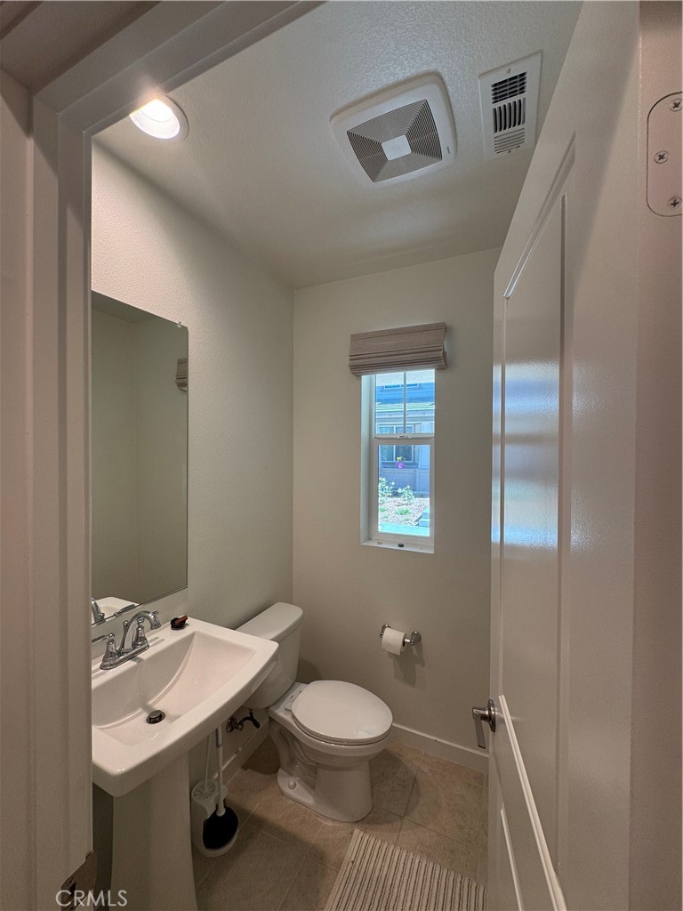 32412 Tannat Drive Temecula, CA 92591 - Photo 11 of 28 a bathroom with a toilet a sink and mirror