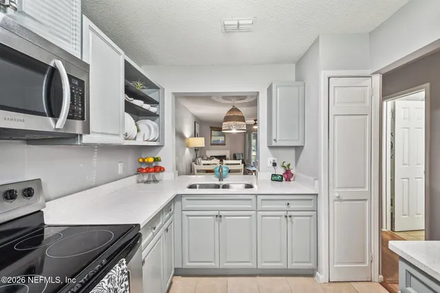 a kitchen with stainless steel appliances a sink stove and cabinets