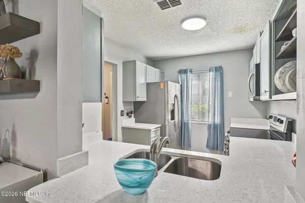 a kitchen with stainless steel appliances a sink and a refrigerator