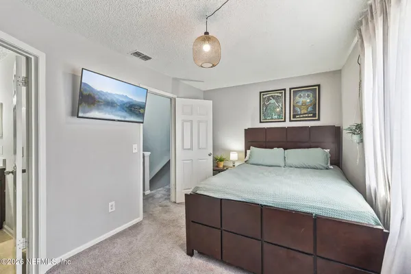a bedroom with a large bed and a chandelier