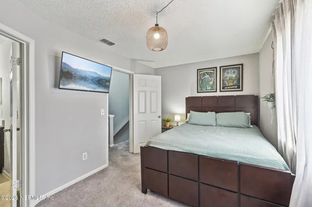 a bedroom with a large bed and a chandelier