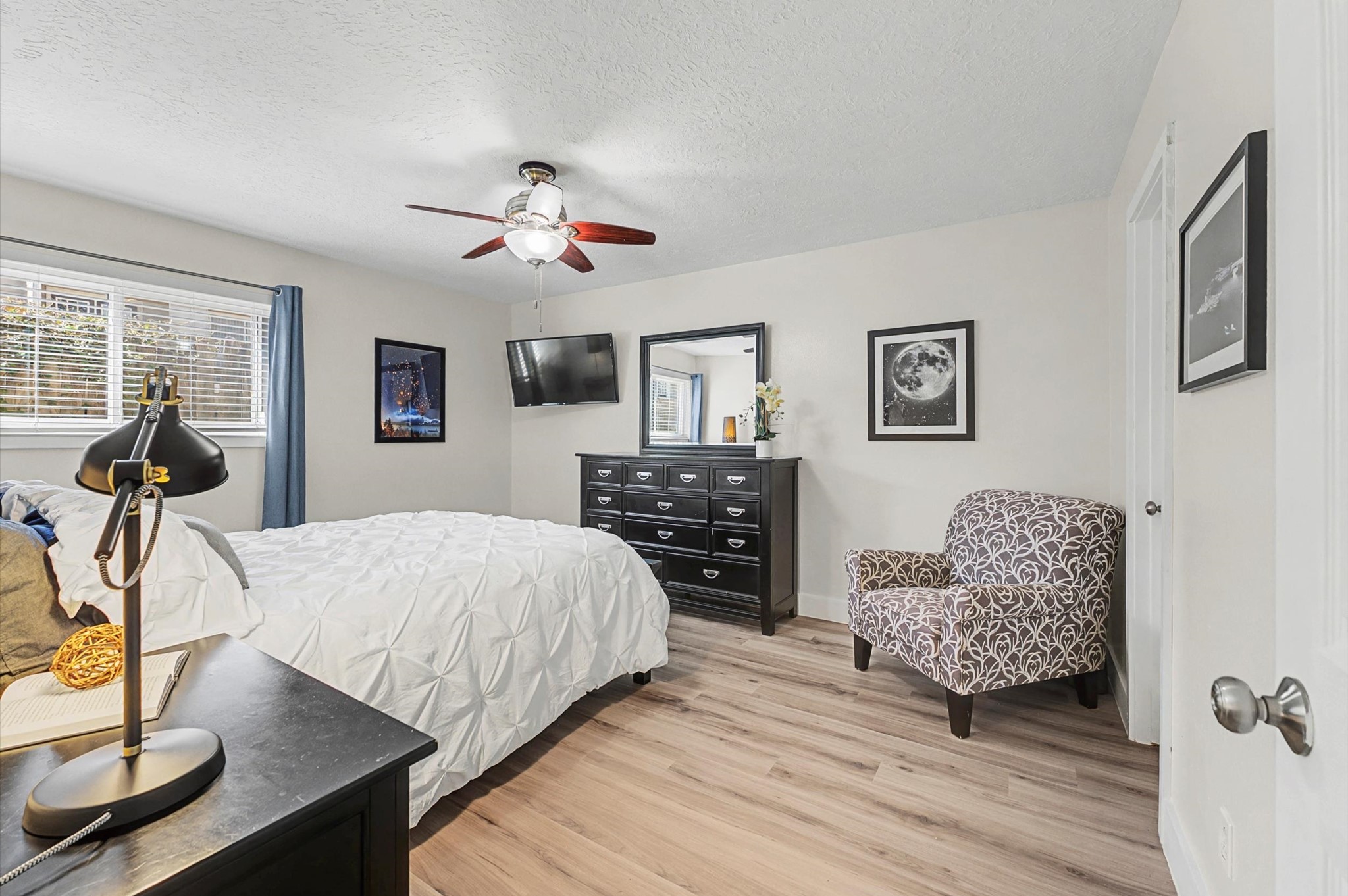 3224 Timmons Lane, Unit 141 Houston, TX 77027 - Photo 9 of 15 a bedroom with a bed and dresser with mirror