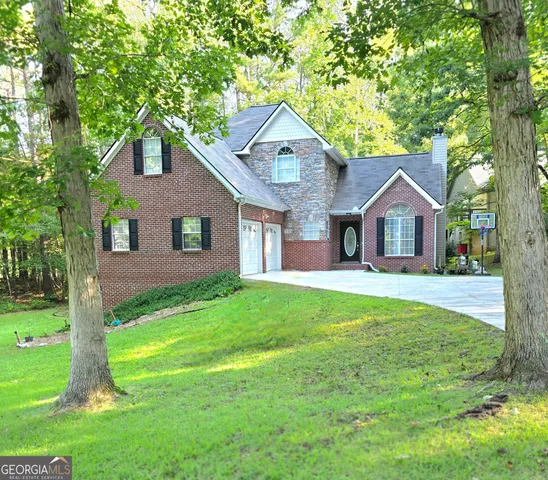 a front view of a house with yard and tree