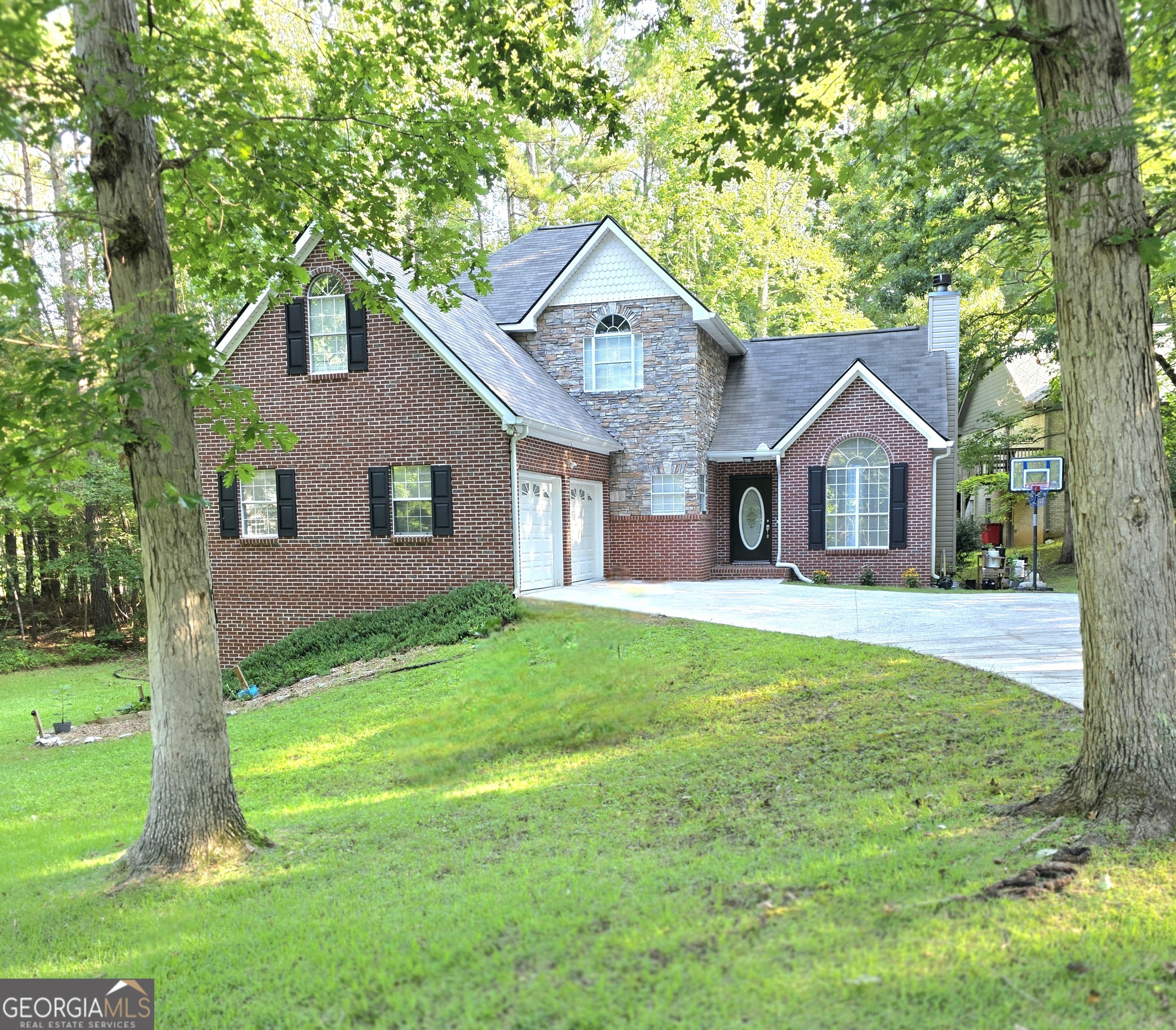 a front view of a house with yard and tree