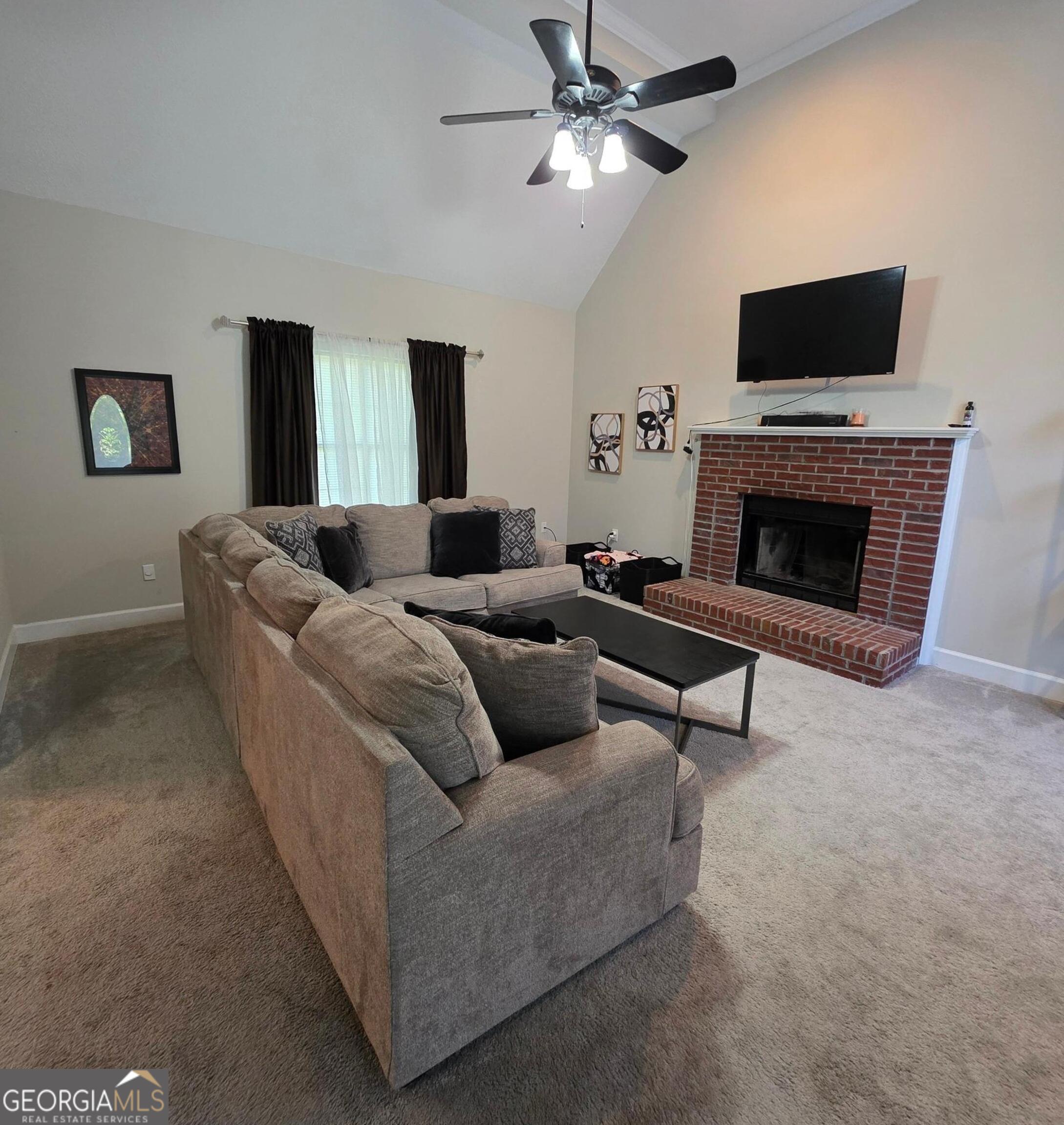 3117 Fairmond Court Villa Rica, GA 30180 - Photo 3 of 20 a living room with furniture a fireplace and a flat screen tv