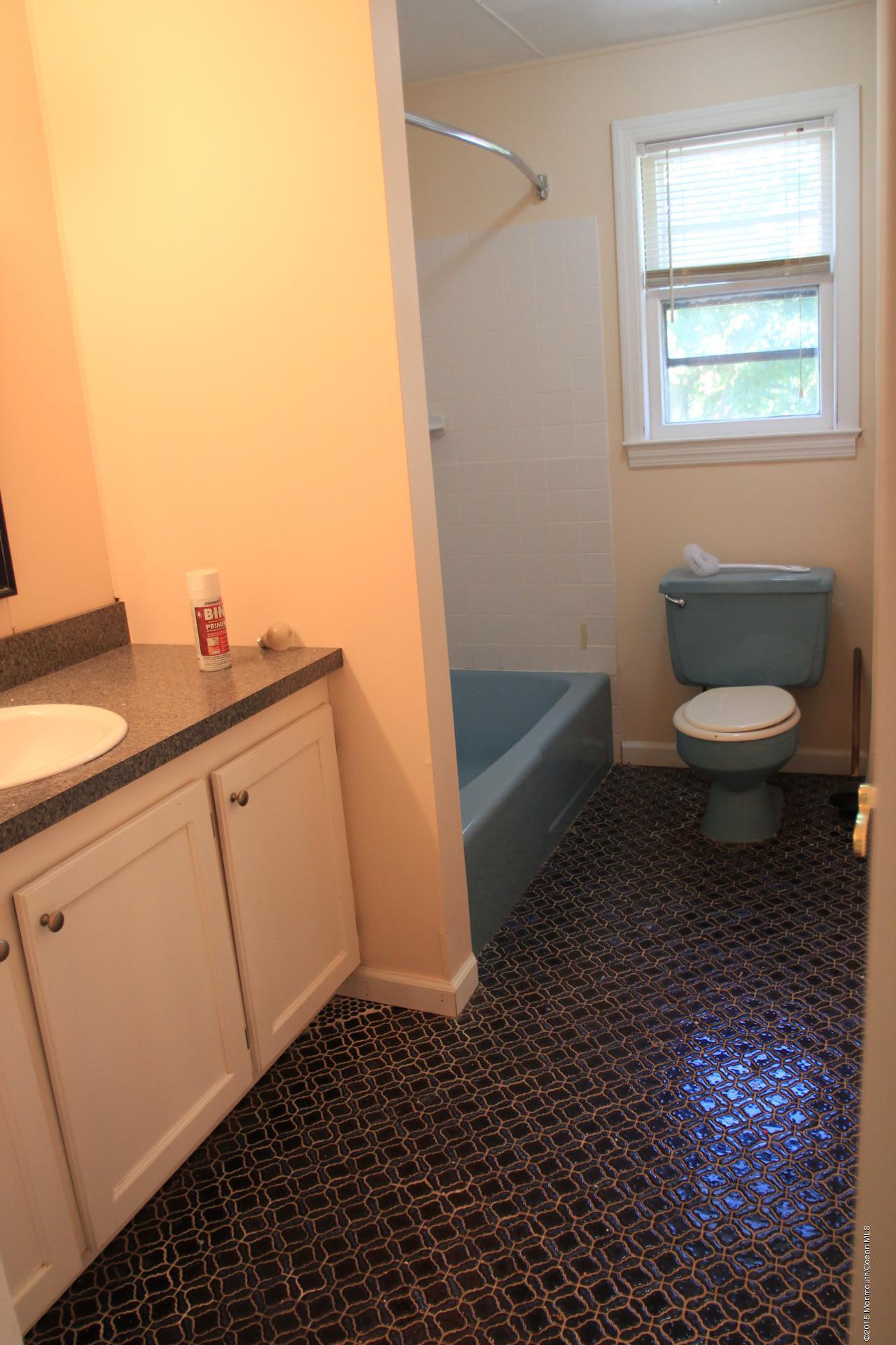 121 Branchport Avenue, Unit A Long Branch, NJ 07740 - Photo 17 of 21 a bathroom with a toilet a sink and a window