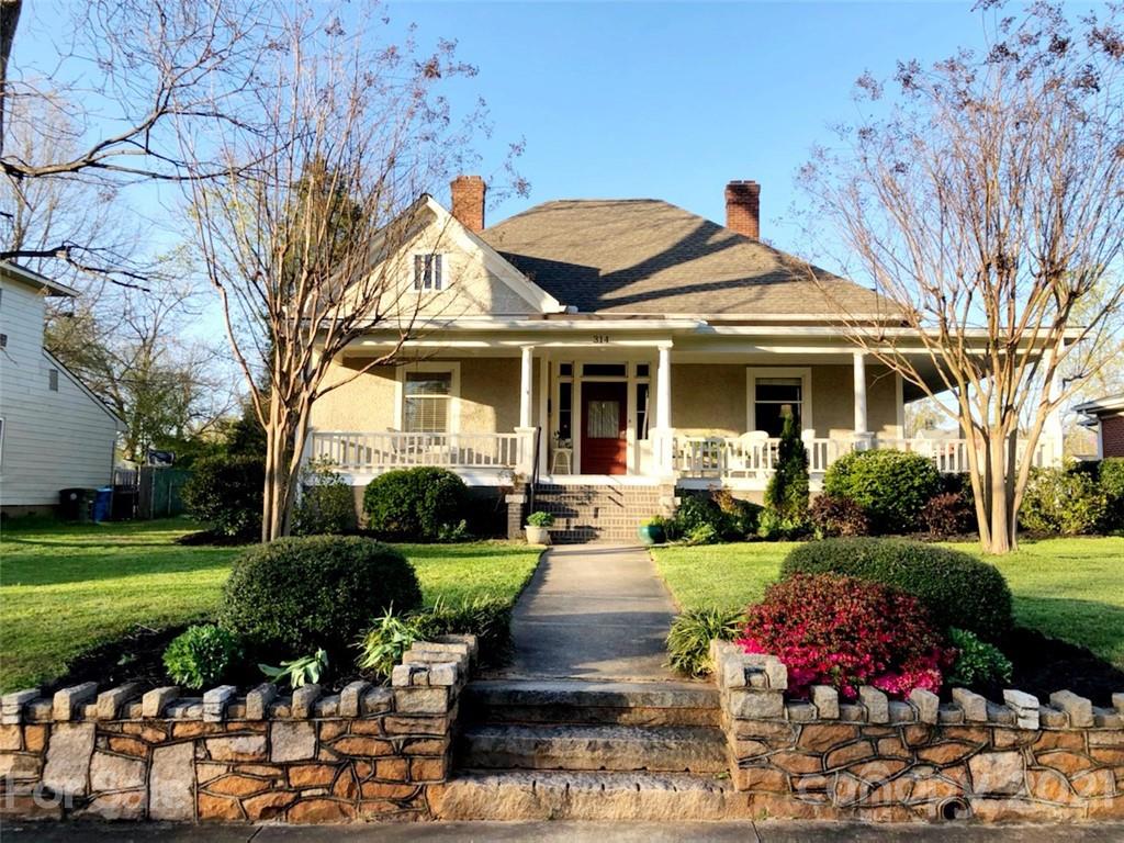 a front view of a house with yard and green space