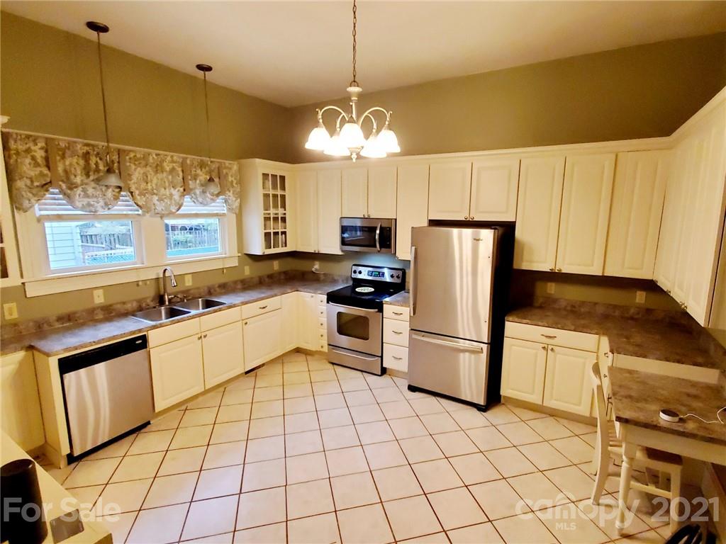 314 Mitchell Avenue Salisbury, NC 28144 - Photo 5 of 19 a kitchen with stainless steel appliances granite countertop a refrigerator a sink dishwasher a stove and white cabinets with wooden floor