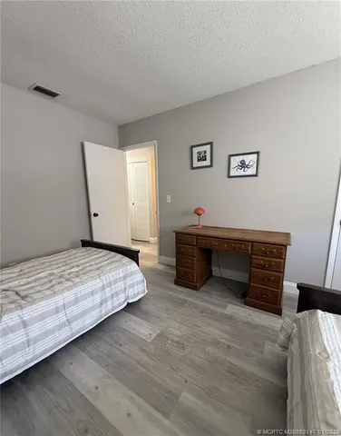 a spacious bedroom with a bed and cabinet