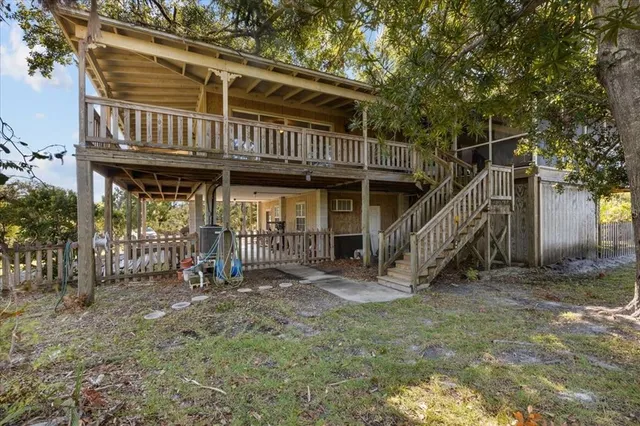 a view of a house with backyard and trees