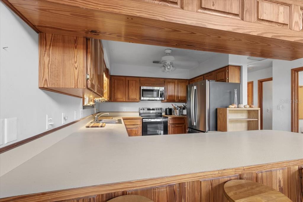 16791 Sandra Street Cedar Key, FL 32625 - Photo 16 of 50 a kitchen with stainless steel appliances a refrigerator a sink a stove and cabinets
