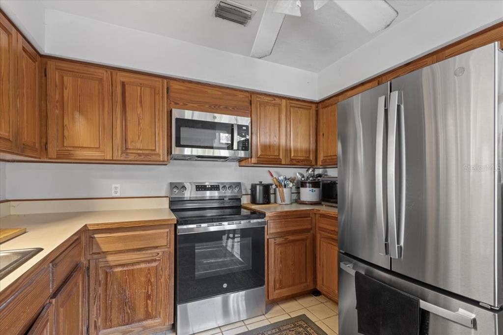 16791 Sandra Street Cedar Key, FL 32625 - Photo 18 of 50 a kitchen with stainless steel appliances granite countertop a refrigerator stove top oven a sink and dishwasher