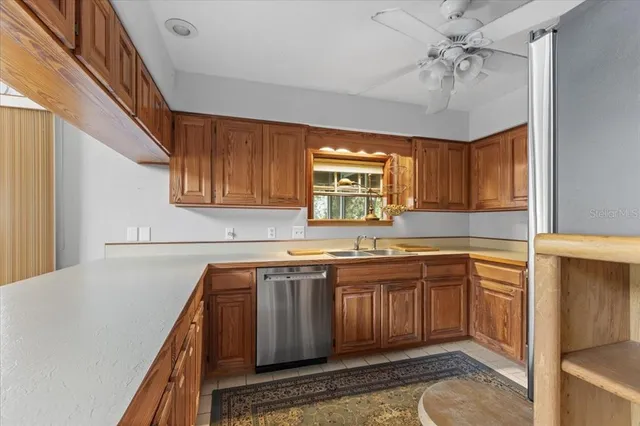 a kitchen with stainless steel appliances granite countertop a refrigerator stove top oven a sink and dishwasher