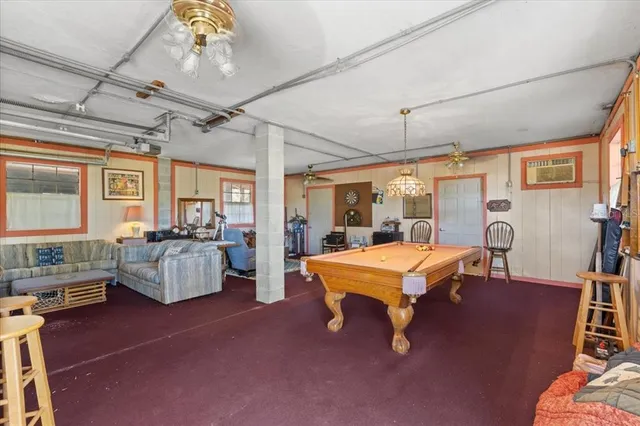 a living room with furniture a rug and a floor to ceiling window