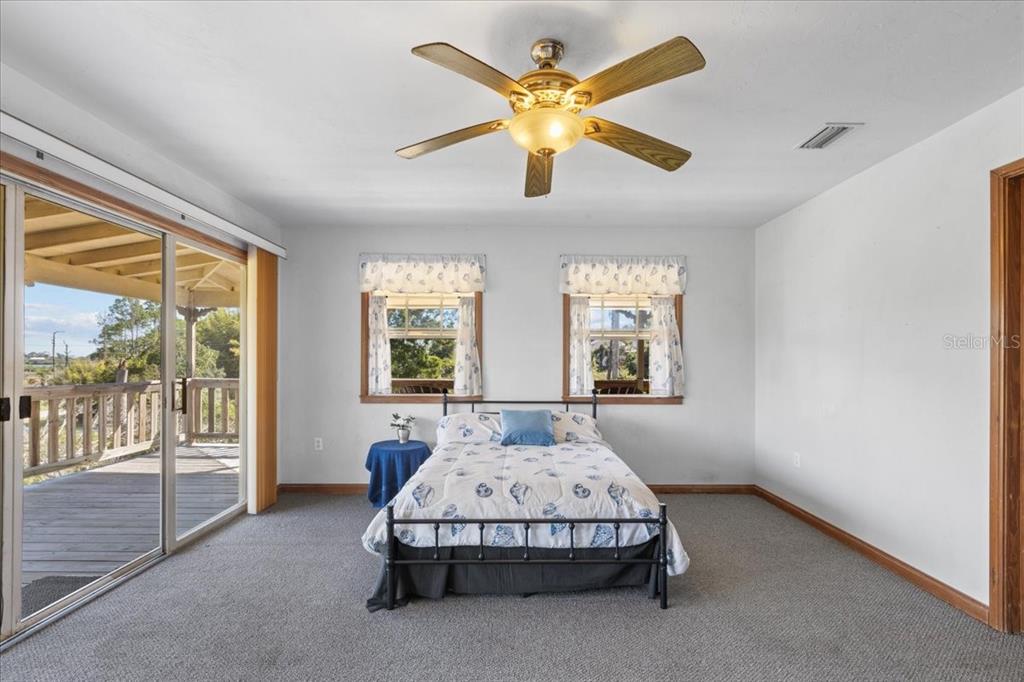 16791 Sandra Street Cedar Key, FL 32625 - Photo 25 of 50 a spacious bedroom with a bed and large windows
