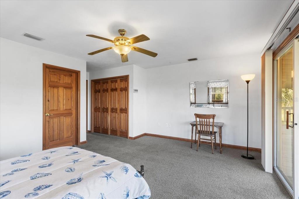 16791 Sandra Street Cedar Key, FL 32625 - Photo 29 of 50 a bedroom with a bed and a chandelier