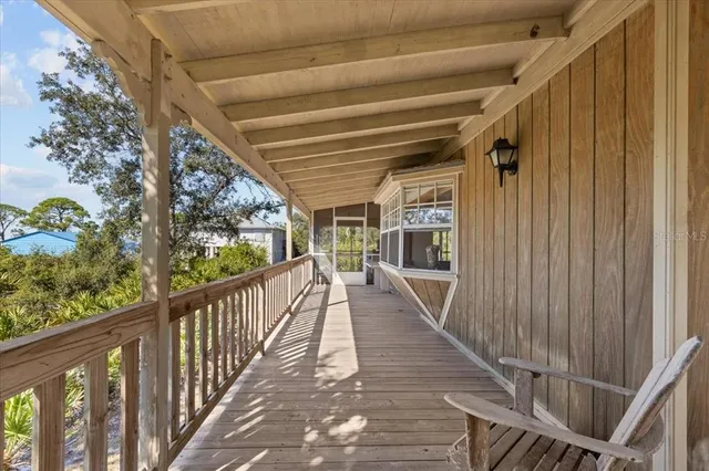 a view of a porch with wooden floor and iron stairs