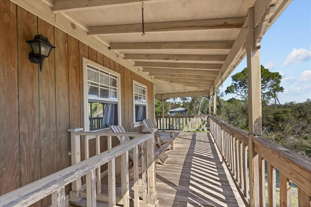 16791 Sandra Street Cedar Key, FL 32625 - Photo 36 of 50 a view of a porch with wooden floor and iron stairs
