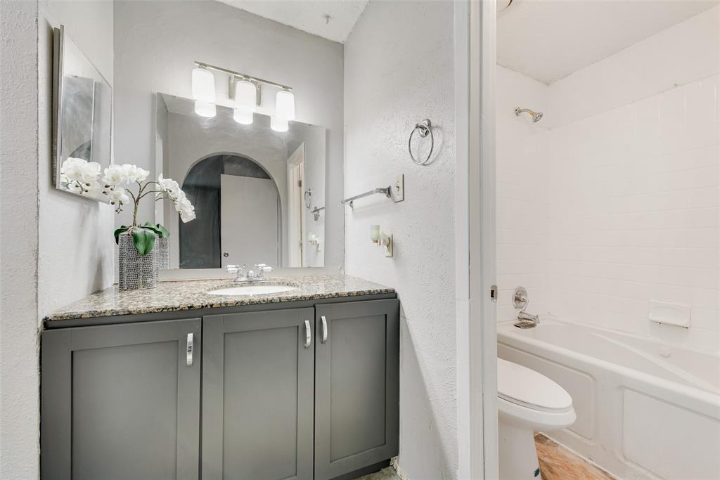 711 Valley Hill Road Duncanville, TX 75137 - Photo 12 of 20 a bathroom with a granite countertop sink a toilet and a bathtub