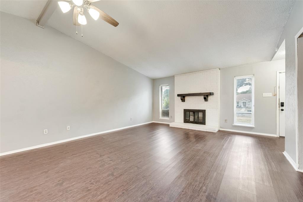 711 Valley Hill Road Duncanville, TX 75137 - Photo 6 of 20 an empty room with wooden floor fireplace and windows