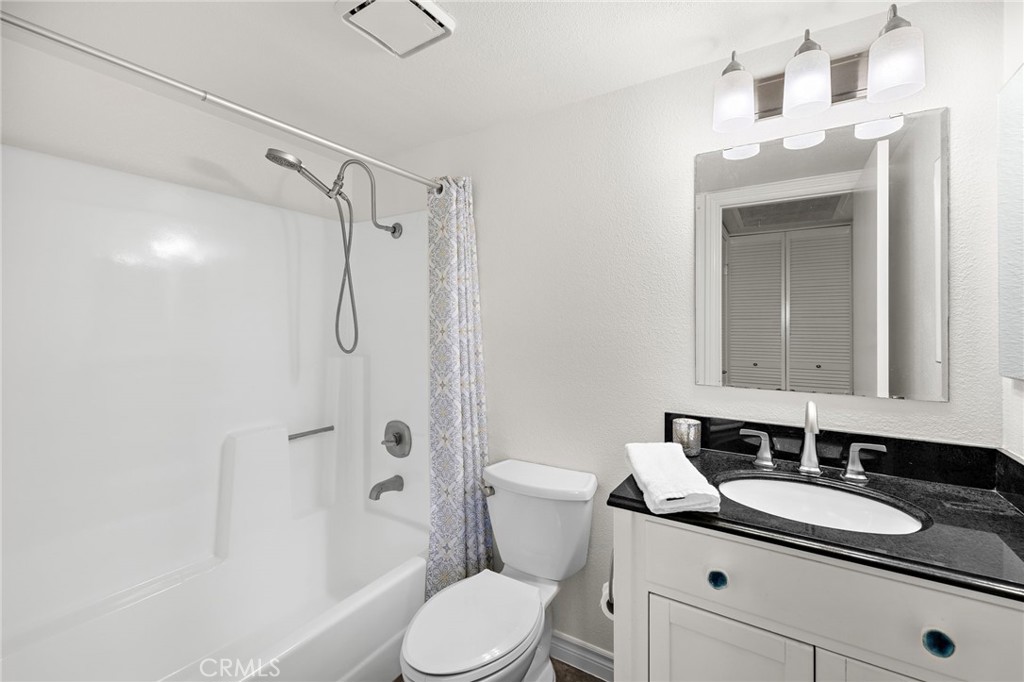 25611 Quail Run, Unit 131 Dana Point, CA 92629 - Photo 10 of 25 a bathroom with a granite countertop sink toilet a mirror and shower