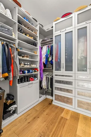 a view of walk in closet with clothes and shoes