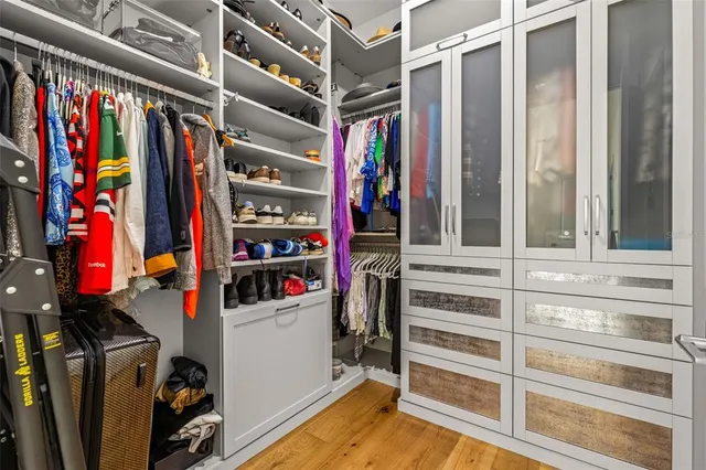 a view of walk in closet with clothes and shoes