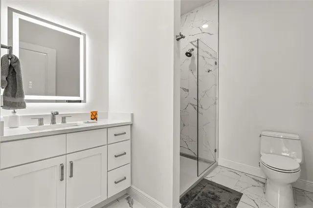 a bathroom with a granite countertop sink toilet and shower