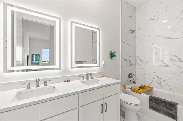 a bathroom with a sink mirror vanity and toilet