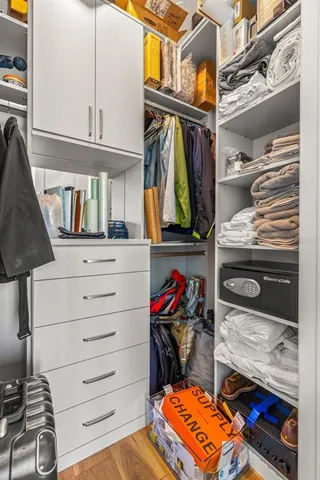a view of walk in closet with clothes and shoes