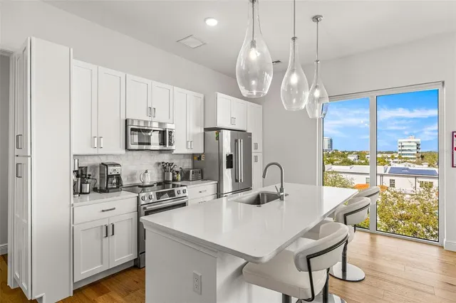 a kitchen with stainless steel appliances a table chairs and cabinets