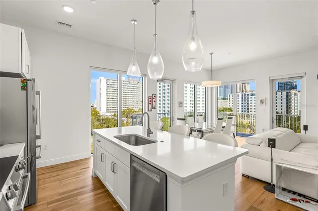 a large white kitchen with a large window and stainless steel appliances