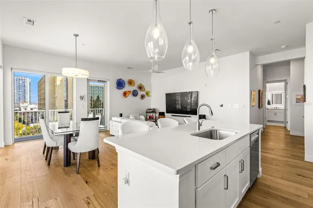 a large kitchen with kitchen island stainless steel appliances a table chairs and a chandelier