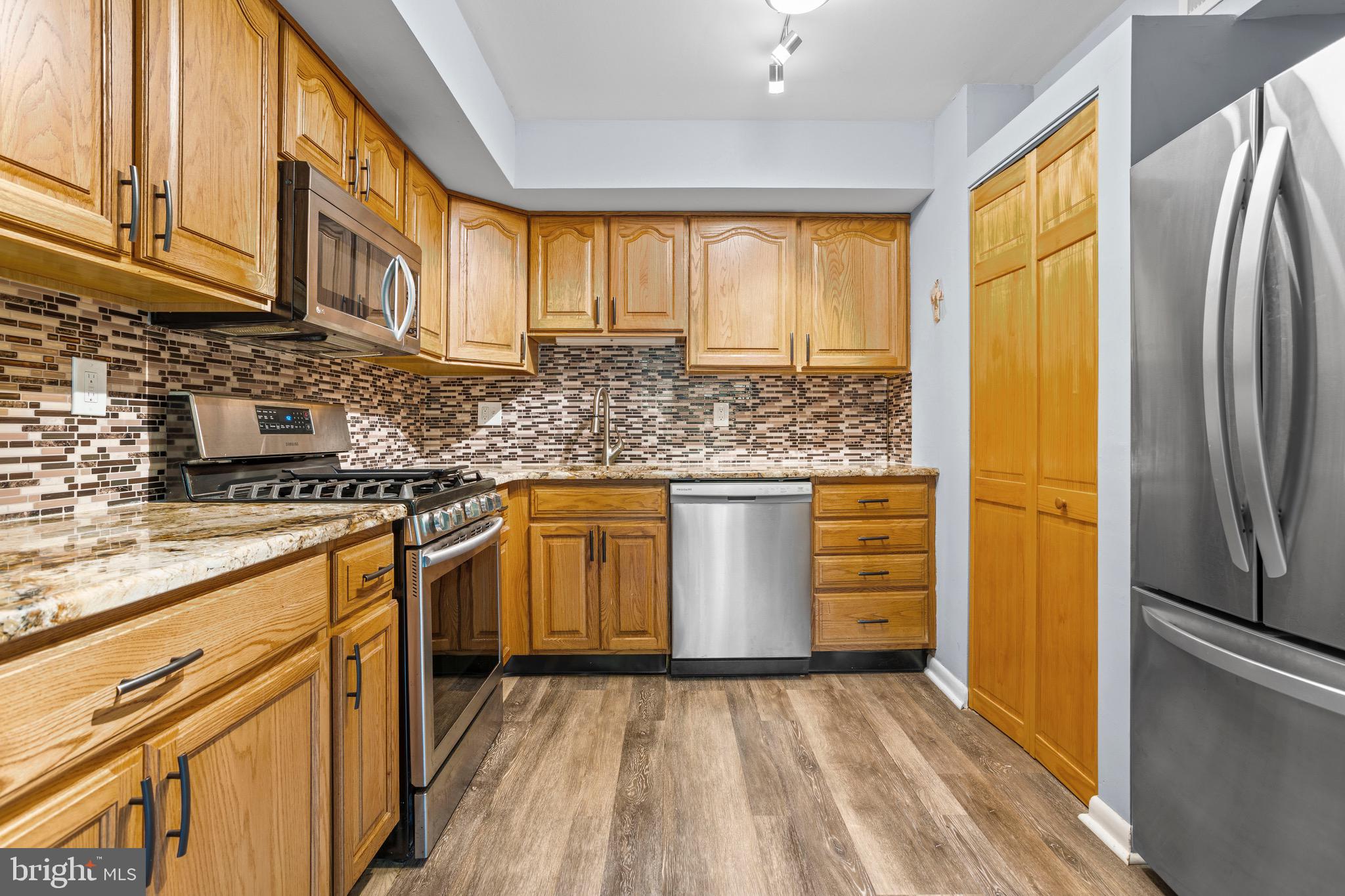 1511 Painters Crossing, Unit 1511 Chadds Ford, PA 19317 - Photo 7 of 17 a kitchen with stainless steel appliances granite countertop a refrigerator a stove and a sink with cabinets