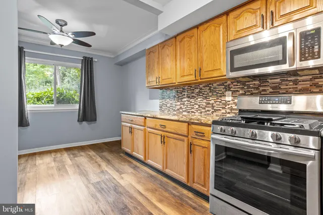 a kitchen with stainless steel appliances granite countertop a stove and a microwave