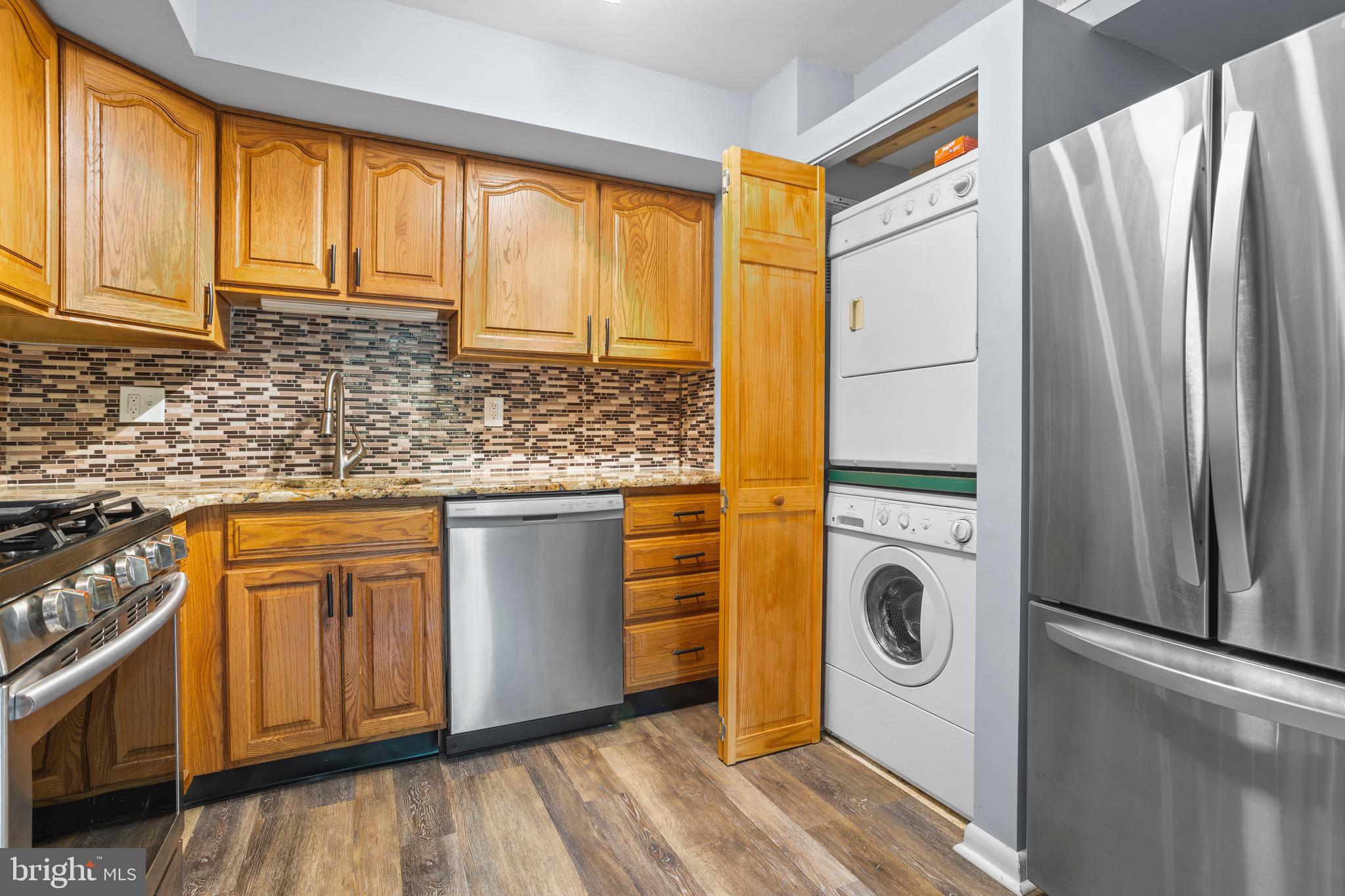 1511 Painters Crossing, Unit 1511 Chadds Ford, PA 19317 - Photo 9 of 17 a kitchen with stainless steel appliances granite countertop a refrigerator a sink and a stove