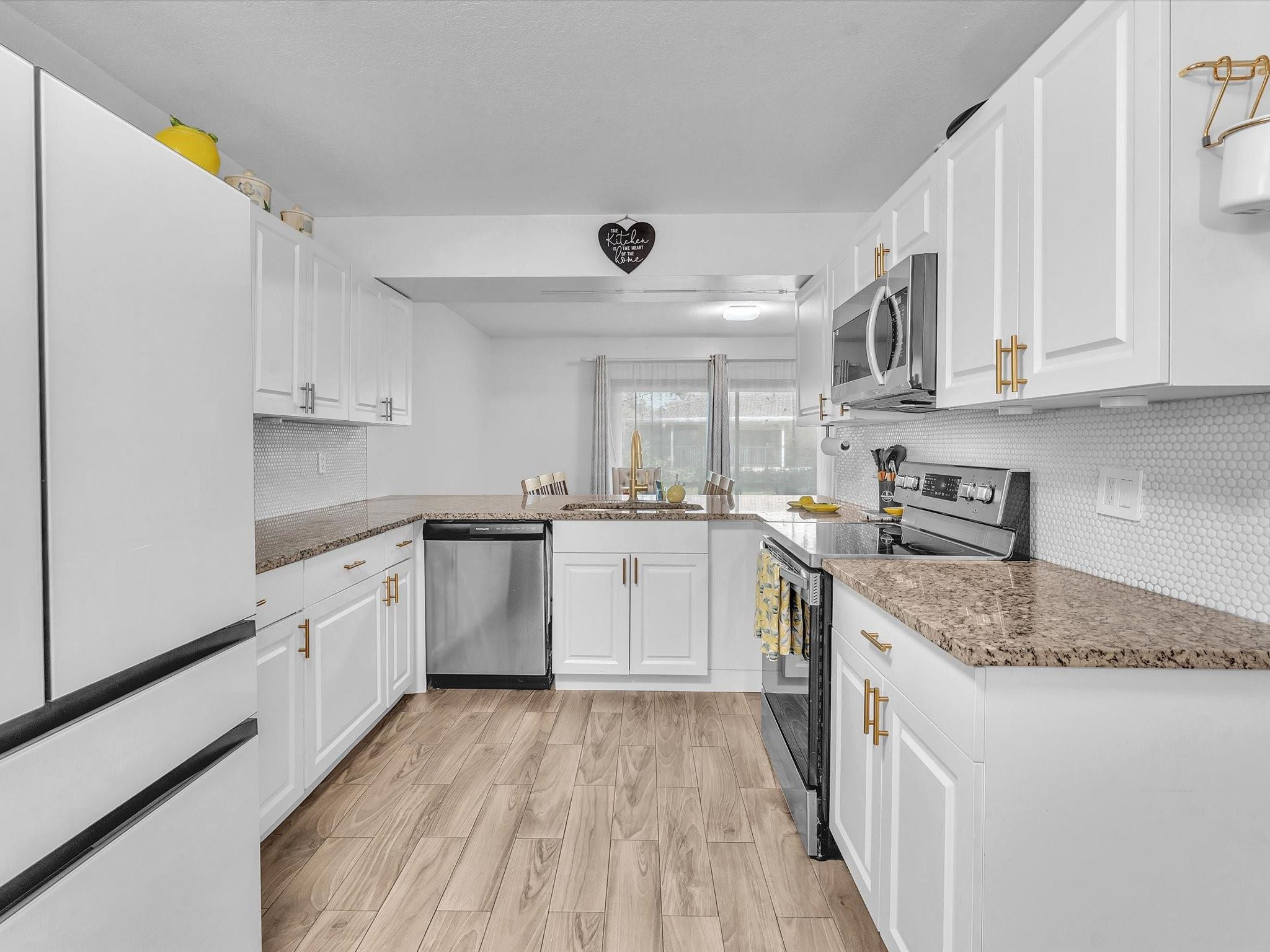 a kitchen with granite countertop white cabinets and white appliances
