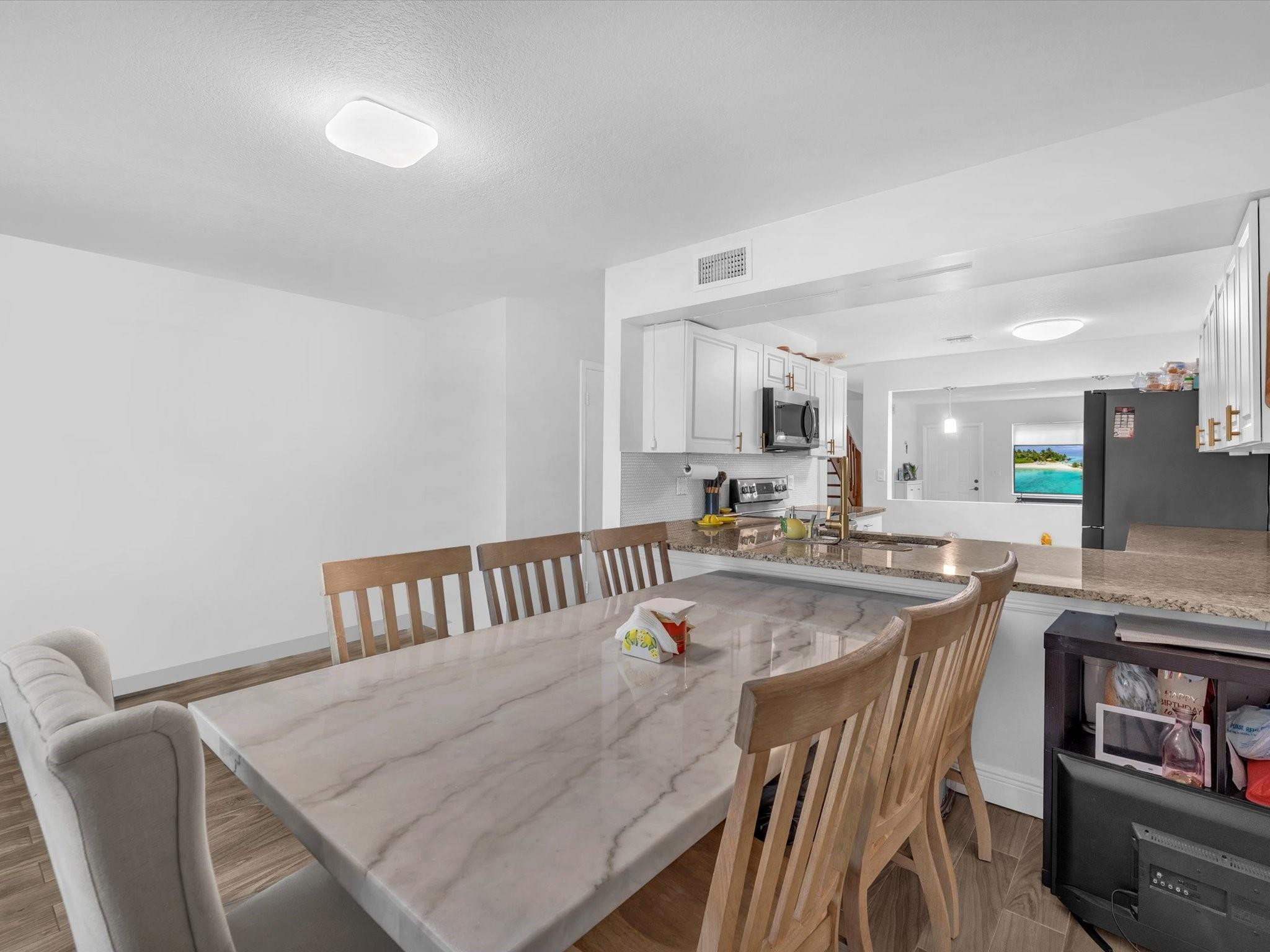 9831 Riverside Drive Coral Springs, FL 33071 - Photo 11 of 27 a dining hall with stainless steel appliances granite countertop a stove a sink a dining table and chairs