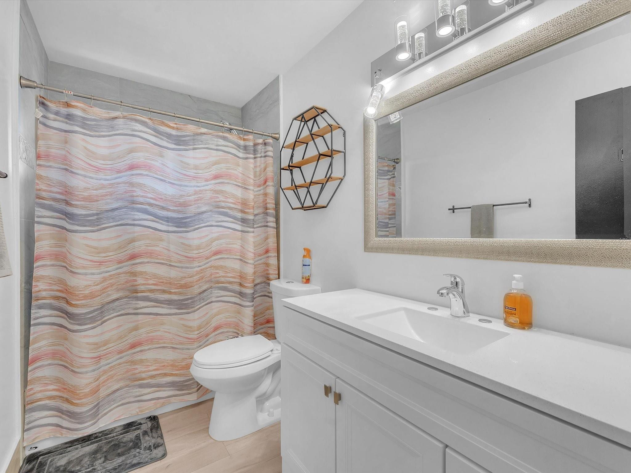 9831 Riverside Drive Coral Springs, FL 33071 - Photo 18 of 27 a bathroom with a sink a toilet and shower curtain