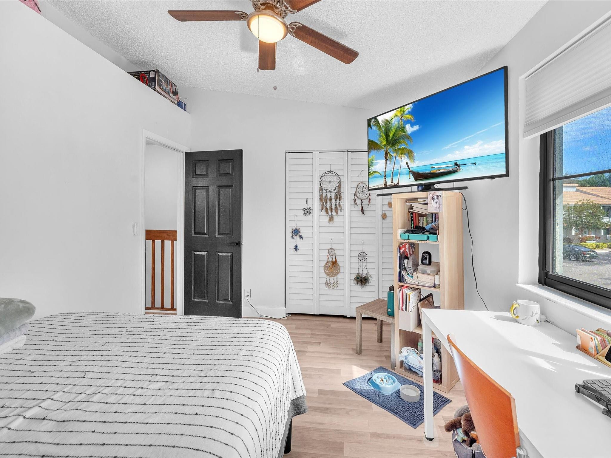 9831 Riverside Drive Coral Springs, FL 33071 - Photo 21 of 27 a bedroom with a bed dresser and a flat tv screen