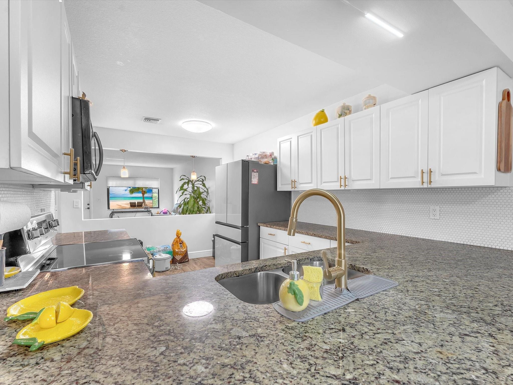 9831 Riverside Drive Coral Springs, FL 33071 - Photo 5 of 27 a kitchen with a stove a refrigerator and cabinets